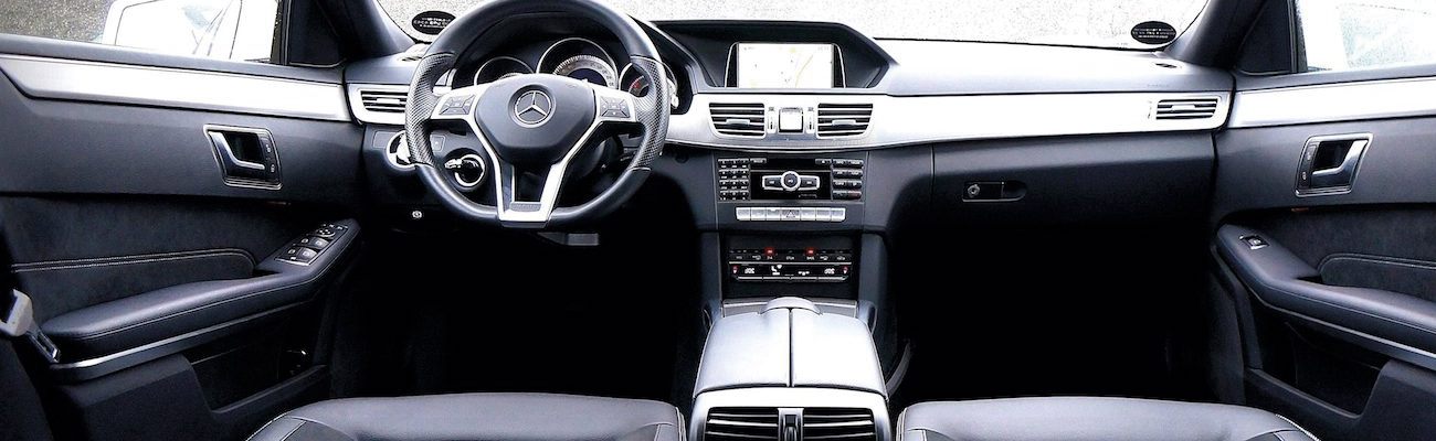 Interior view of a modern car showcasing luxurious black leather seats, a sleek dashboard with infotainment system, and a contemporary steering wheel.